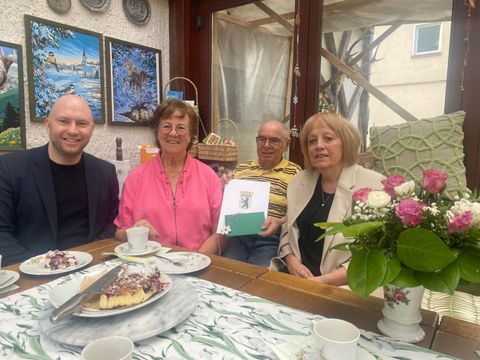 Bezirksstadtrat für Jugend und Familie Alexander Ewers (li.) und die langjährige Familienberaterin der Familie Meike Mielke (AWO pro:mensch/re.) ehren gemeinsam das Ehepaar Ottke für ihr außergewöhnliches Engagement als Pflegeeltern. (Bild: BA Rdf)