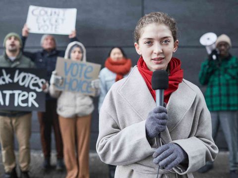 Mädchen steht mit Mikrofon vor jungen Demonstrant*innen