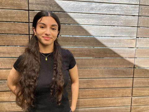 Aziza Egla vor Holzwand