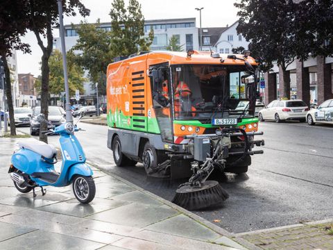 Mittelgroße BSR-Kehrmaschine bei der Fahrbahnreinigung