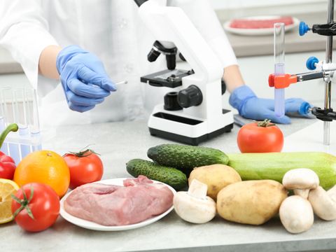 Scientist checking products at table in laboratory, closeup. Quality control