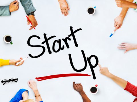 Schriftzug Start Up umgeben von Händen