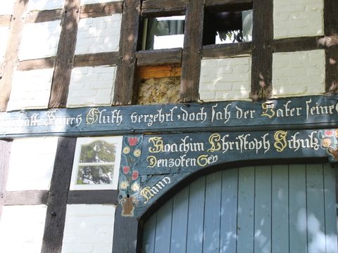 Fassade eines typischen Rundlingsdorf-Hauses, kunstvoll beschriftet und mit viel Fachwerk