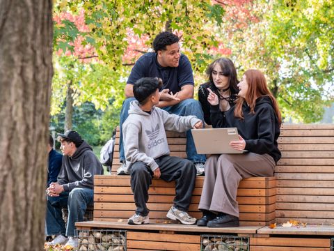 Jugendliche mit Laptop auf Schulhof