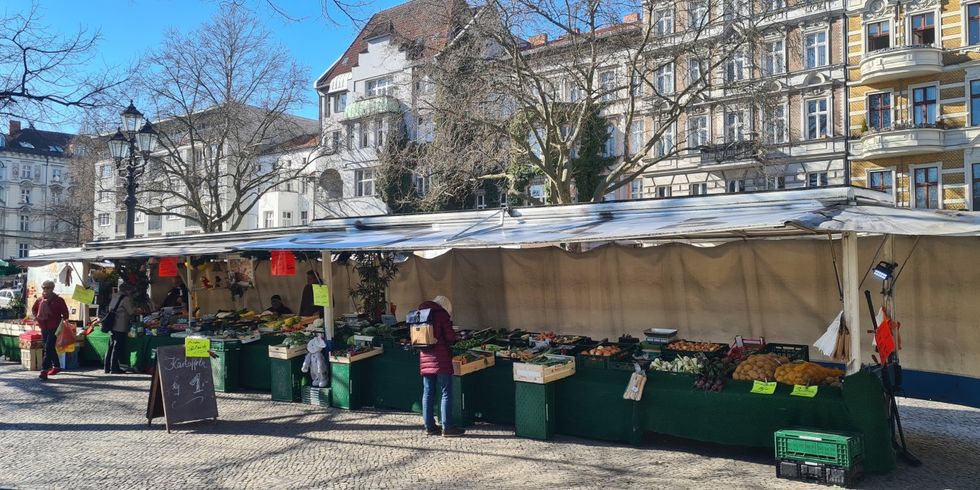 Wochenmarkt am Klausenerplatz: Eine Reihe Verkaufsstände mit Gemüse und Obst
