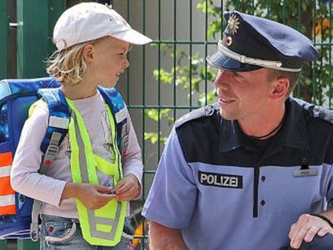 Polizist mit einem Kind am Straßenrand