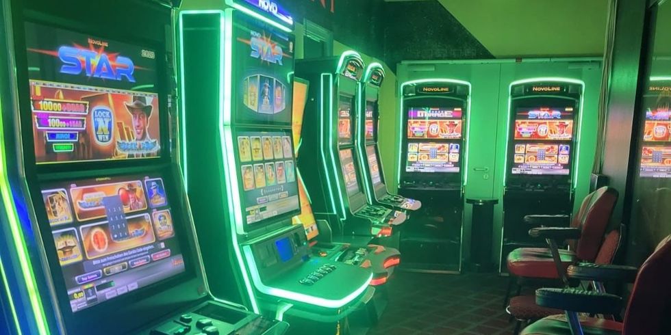 Mehrere Spielautomaten im grünen Neonlicht einer durchsuchten Gaststätte