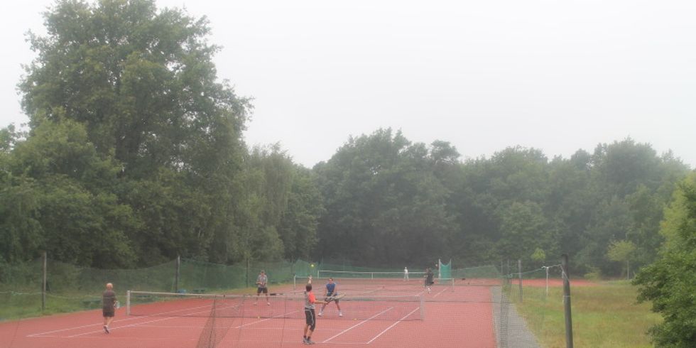 Tennisspieler auf rotem Tennisplatz