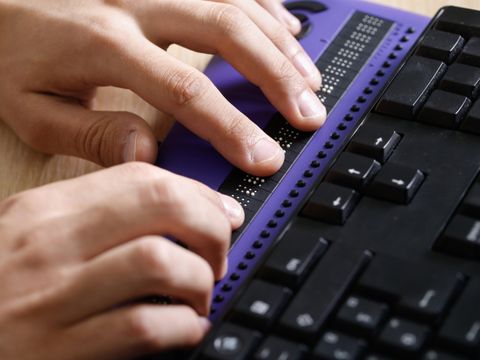 Blind person using computer with braille computer display