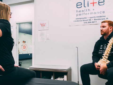 Eine Frau befindet sich in physiotherapeutischer Behandlung und schildert dem Physiotherapeuten ihre Schmerzen im unteren Rücken.