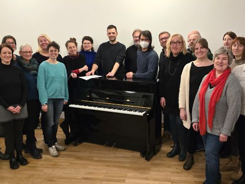 Der Dirigent und Chorleiter Miloš Tadić (mi.) und die Sänger*innen des Kreuzberger Kitschchores während einer Probe