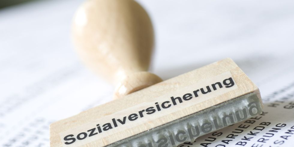 Stempel mit Aufschrift Sozialversicherung liegt auf Gehaltsabrechnung