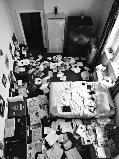 Hotelzimmer mit Papier- und Bücherstapeln