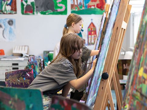 Atelier Farbklecks: Zwei Kinder sitzen an einer Staffelei und malen. (Bild: © Sebastian Runge)