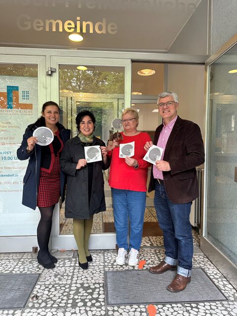 (v.l.n.r.) Einsamkeitsbeauftragte Katharina Schulz, Bezirksbürgermeisterin Emine Demirbüken-Wegner, Leiterin vom Stammtisch gegen Einsamkeit Rosemarie Teichelmann und Pastor Georg Schierling beim Anbringen des Stickers gegen Einsamkeit