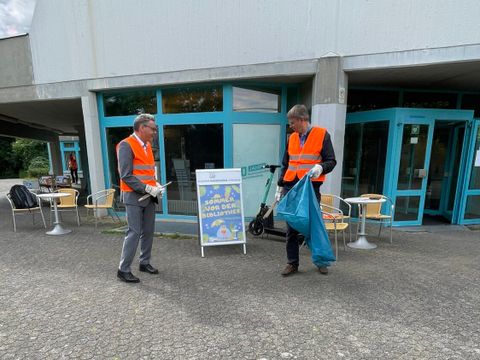 Bezirksbürgermeister Jörn Oltmann (links) und Bezirksstadtrat Tobias Dollase (rechts) bei der Müllsammel-Aktion vor der Bezirkszentralbibliothek