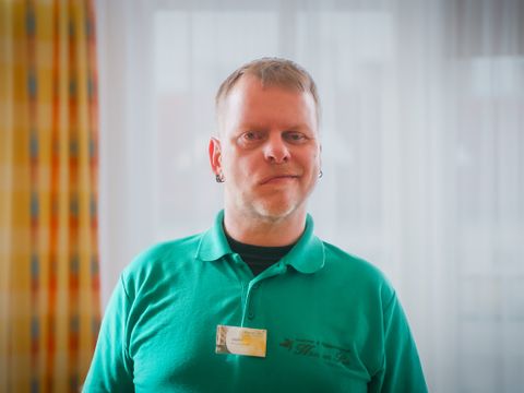 Portrait von Andre in Berufskleidung.