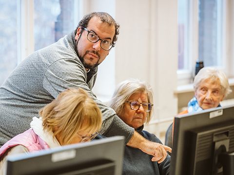 Kursleiter Andre Goslar erklärt einer Frau eine Smartphone-Funktion