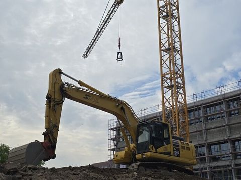 Bagger vor der Sporthalle Fredersdorfer Straße mit Richtkranz beim Richtfest
