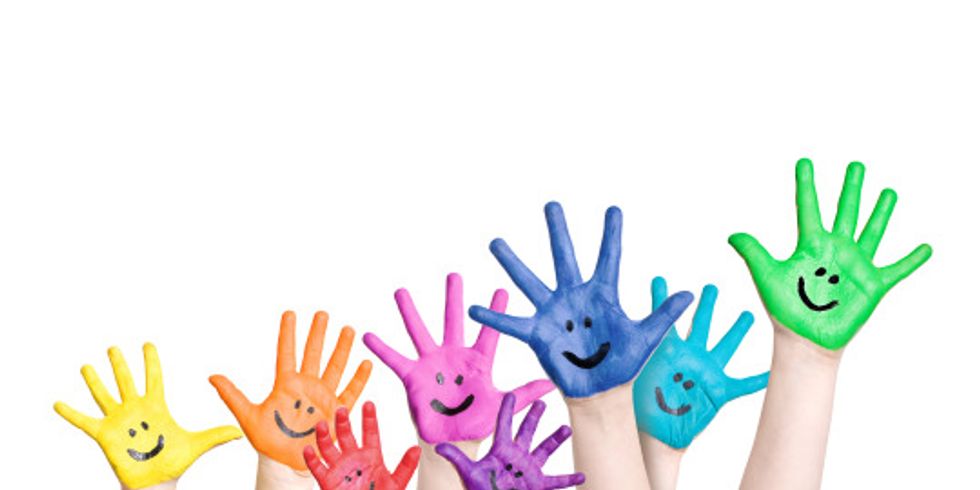 lachende Kinderhände in regenbogenfarben