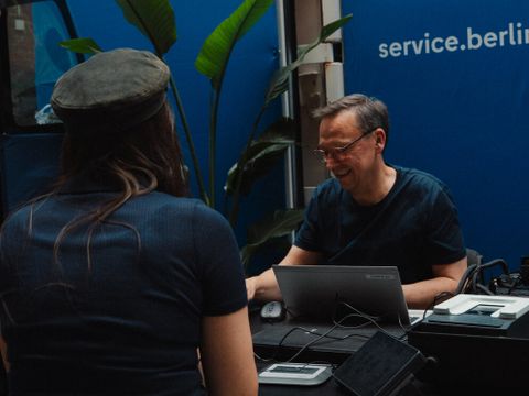 Ansicht eines Mitarbeiter und eine Besucherin beim Stand des Serviceportals