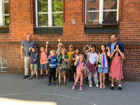 Bezirksstadtrat Benjamin Fritz (r.) und Jarko Hennig von der Schulaufsicht Mitte (l.) mit dem Team der Anna-Lindh-Schule