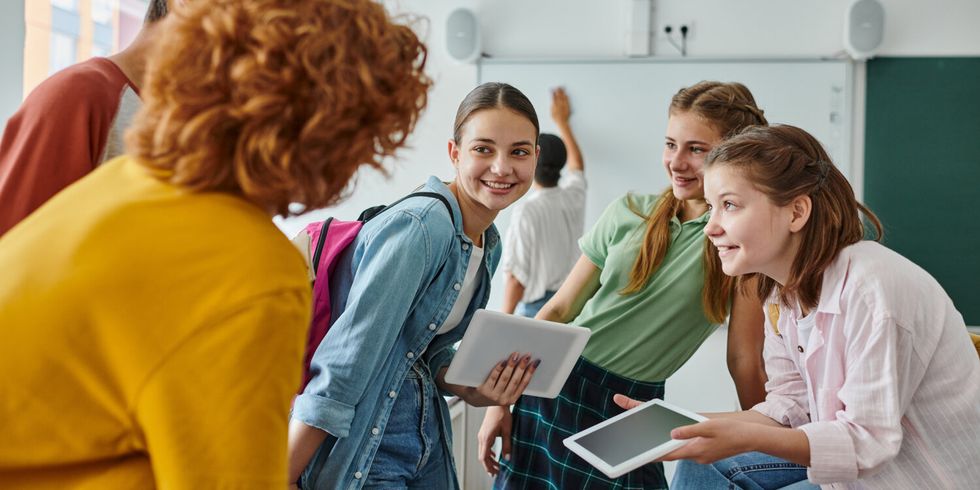 Teenage students engaging and laughing in a vibrant classroom during back-to-school season
