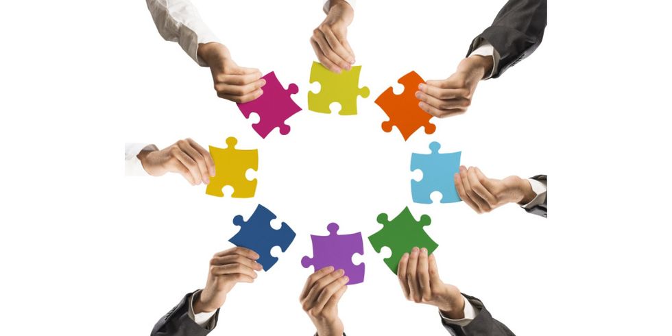 Hände mit Puzzleteilen bilden einen Kreis