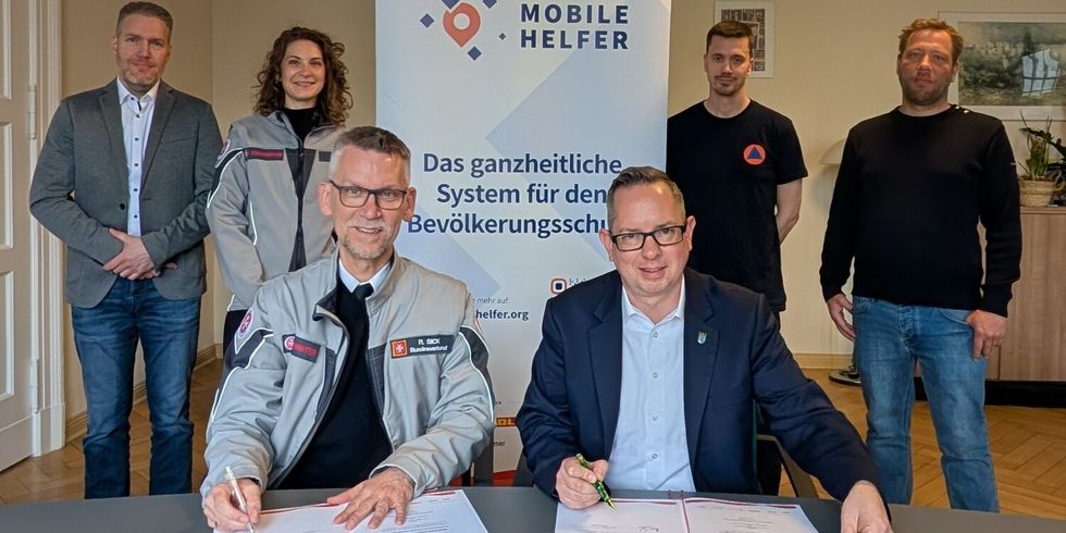Bezirksbürgermeister Oliver Igel (r.) und Ralf Sick (l.), Projektleiter "Mobile Helfer" unterzeichnen die Kooperationsvereinbarung