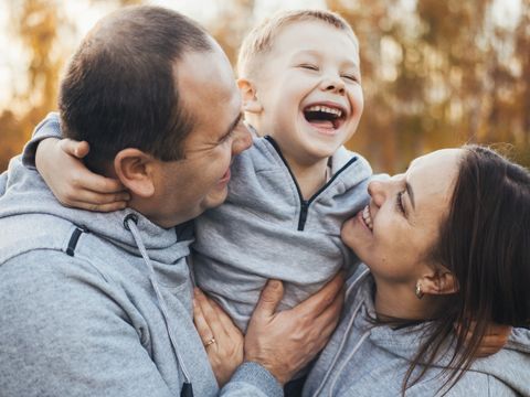 Close-up ortrait of happy family with one kid posing outdoors in public park. Happy people together. Parents and children.