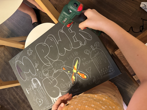 Kinderhände schreiben auf einer Tafel