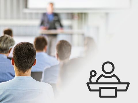 Vortragssituation mit Redner und Zuhörer:innen