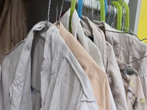 Frisch gereinigte Malkittel hängen für die jungen Künstler*innen bereit