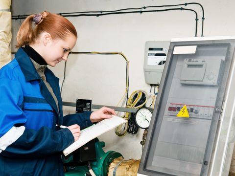 Frau überprüft die Daten einer Heizungsanlage