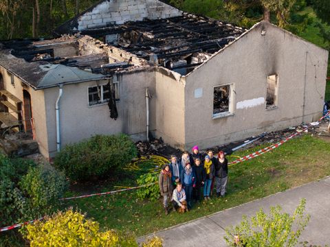 Team des Weltacker Berlin e.V. steht vor dem abgebrannten Ackerhaus