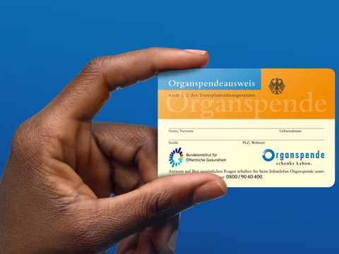 Mensch hält Organspendeausweis in den Händen