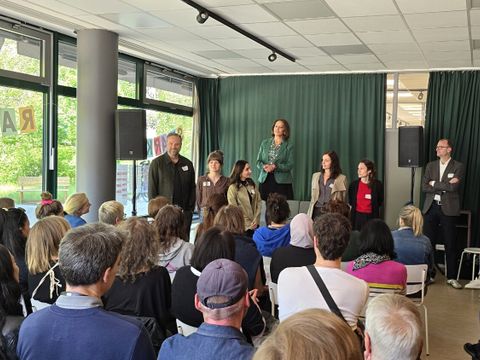 Dr. Jochen Lang (re.), SenStadt, begrüßte die zahlreichen Teilnehmer*innen in den soziokulturellen Projekträumen Bona Peiser und Laila Atrache (mi.,grüne Jacke) erklärte die einzelnen Stationen des Rundgangs
