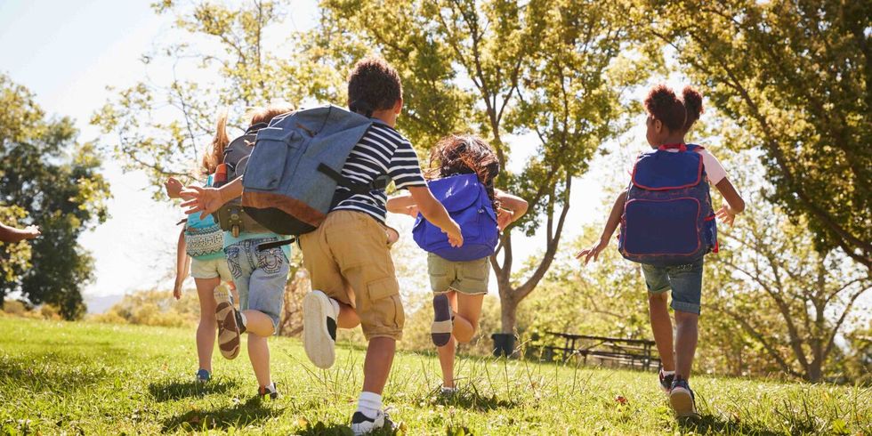 Schulkinder rennen durch einen Park