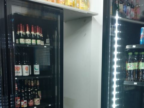 Nur ein schmaler Eingang an den Kühlschränken führt zu dem Hinterzimmer