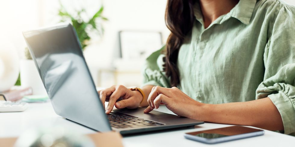 Hände einer Frau am Laptop; sie tippt am Schreibtisch