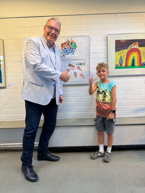 Kulturstadtrat Harald Muschner und der kleine Künstler Milan posieren stolz vor Milans Arbeit (Bild: BA Reinickendorf)