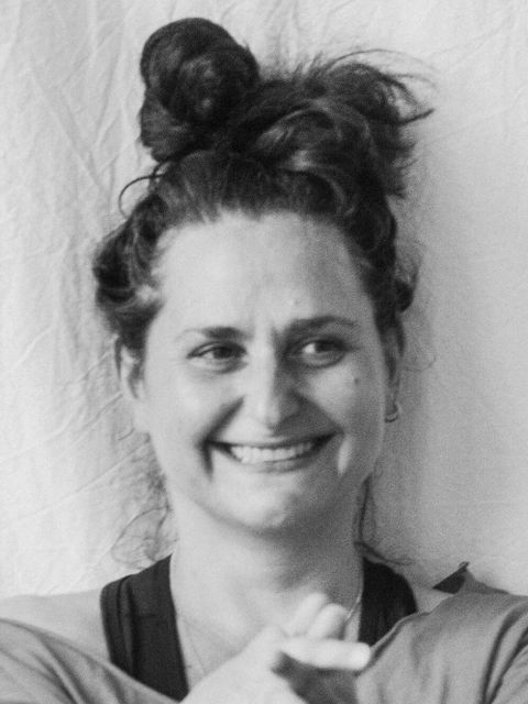 Eine schwarz-weiß Portrait-Fotografie von einer lächelnden Frau.