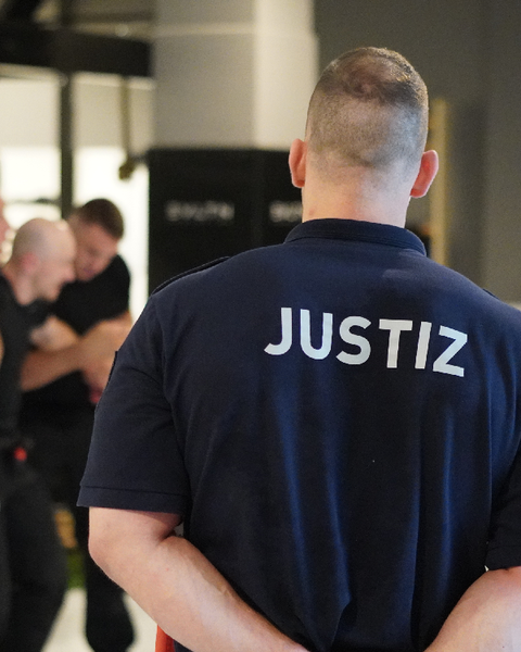 Rücken eines Justizhauptwachtmeister in Uniform zu sehen