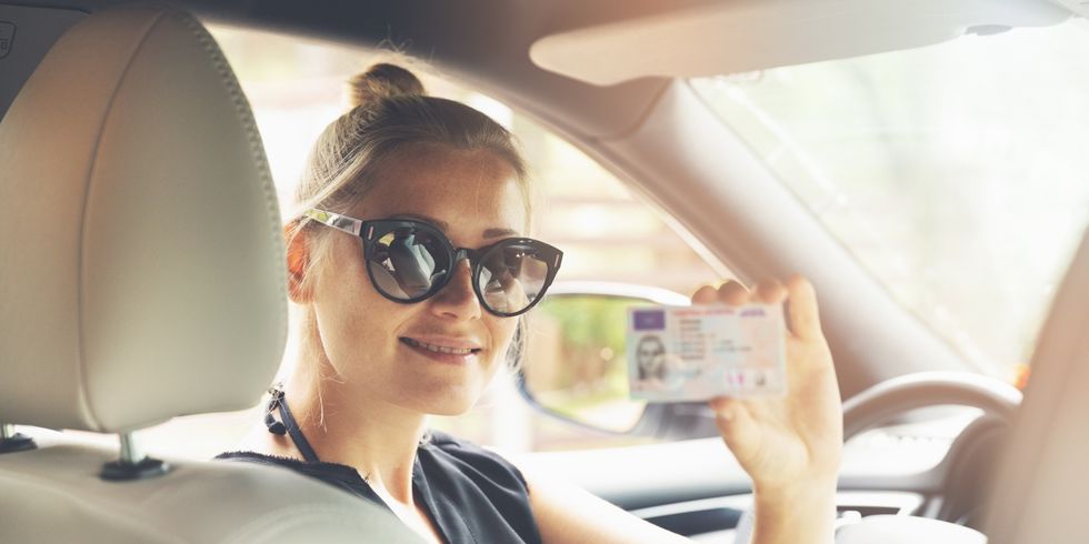 Frau hält Kartenführerschein in die Kamera