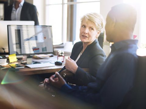 Zwei Menschen im Gespräch am Arbeitsplatz