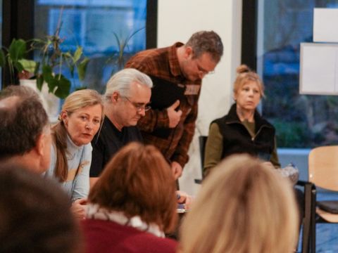 mehrere Personen sitzen zusammen in einem Raum