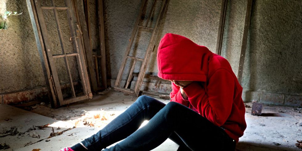 Verzweifelter Teenager sitzt auf dem Boden