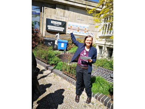 Frau zeigt auf ein Banner zu Ben Wagin