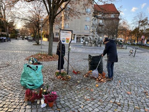 Mittendrin: Der Platz vor dem Schild wird von lästigem Herbstlaub befreit