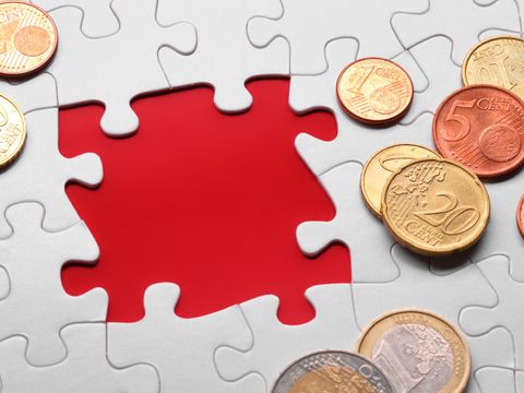 Geldstücke auf Puzzleteilen